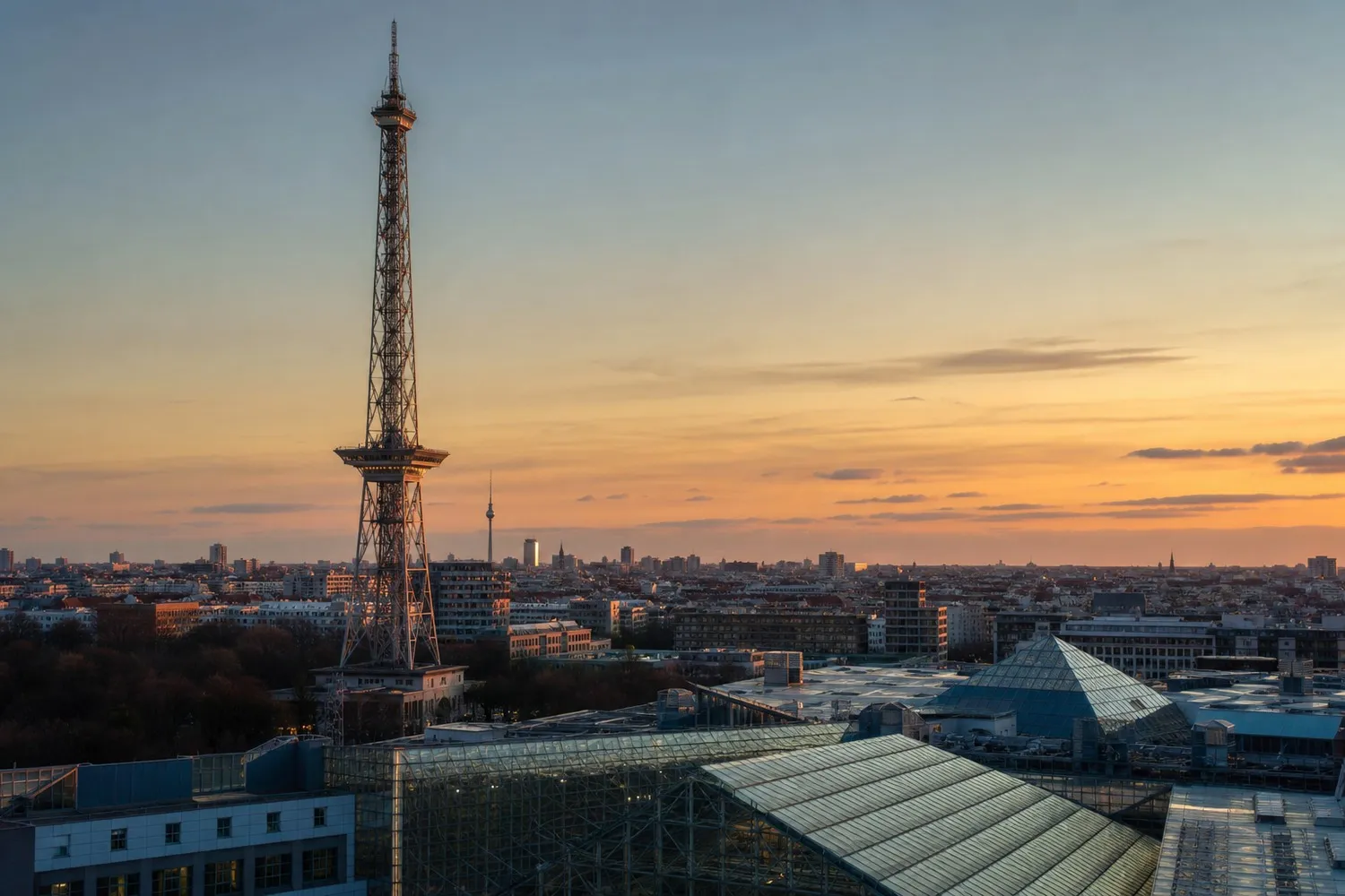Berlin's Funkturm radio tower at golden-hour dusk, overlooking the Messe Berlin fair grounds where IFA takes place
